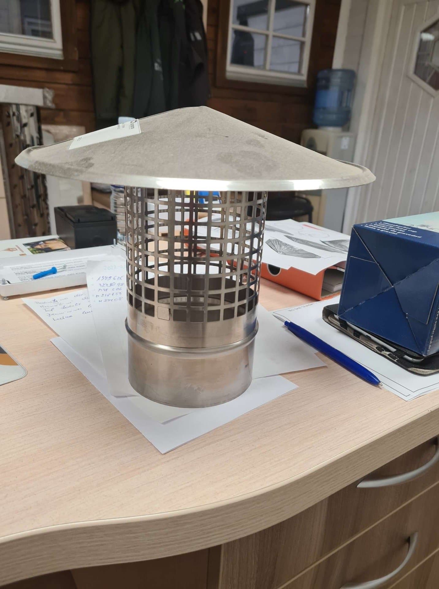 Gnistfanger i rustfritt stål med hatt og gitter, på en pult