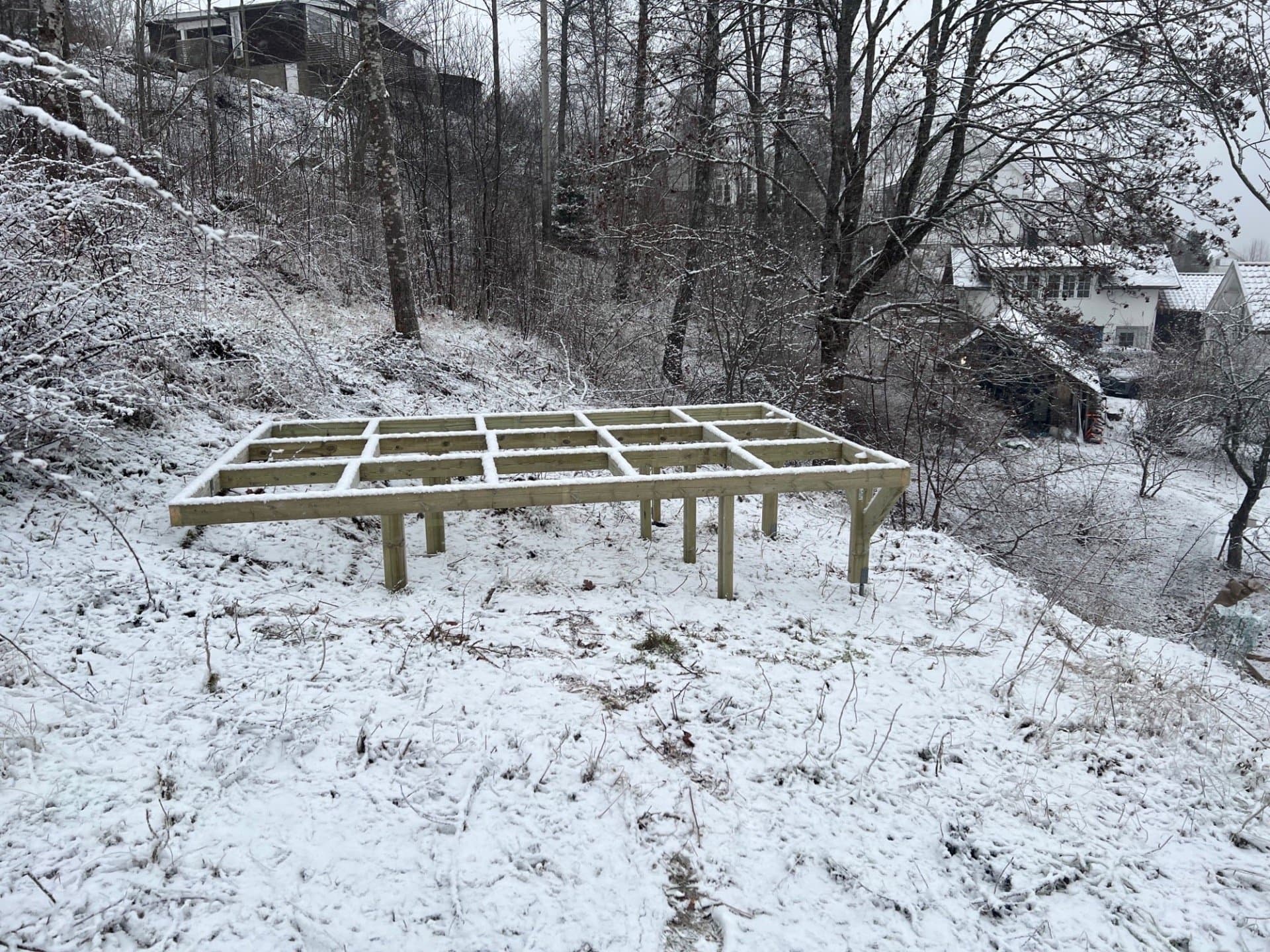 Fundament av tre på stolper, sett fra siden