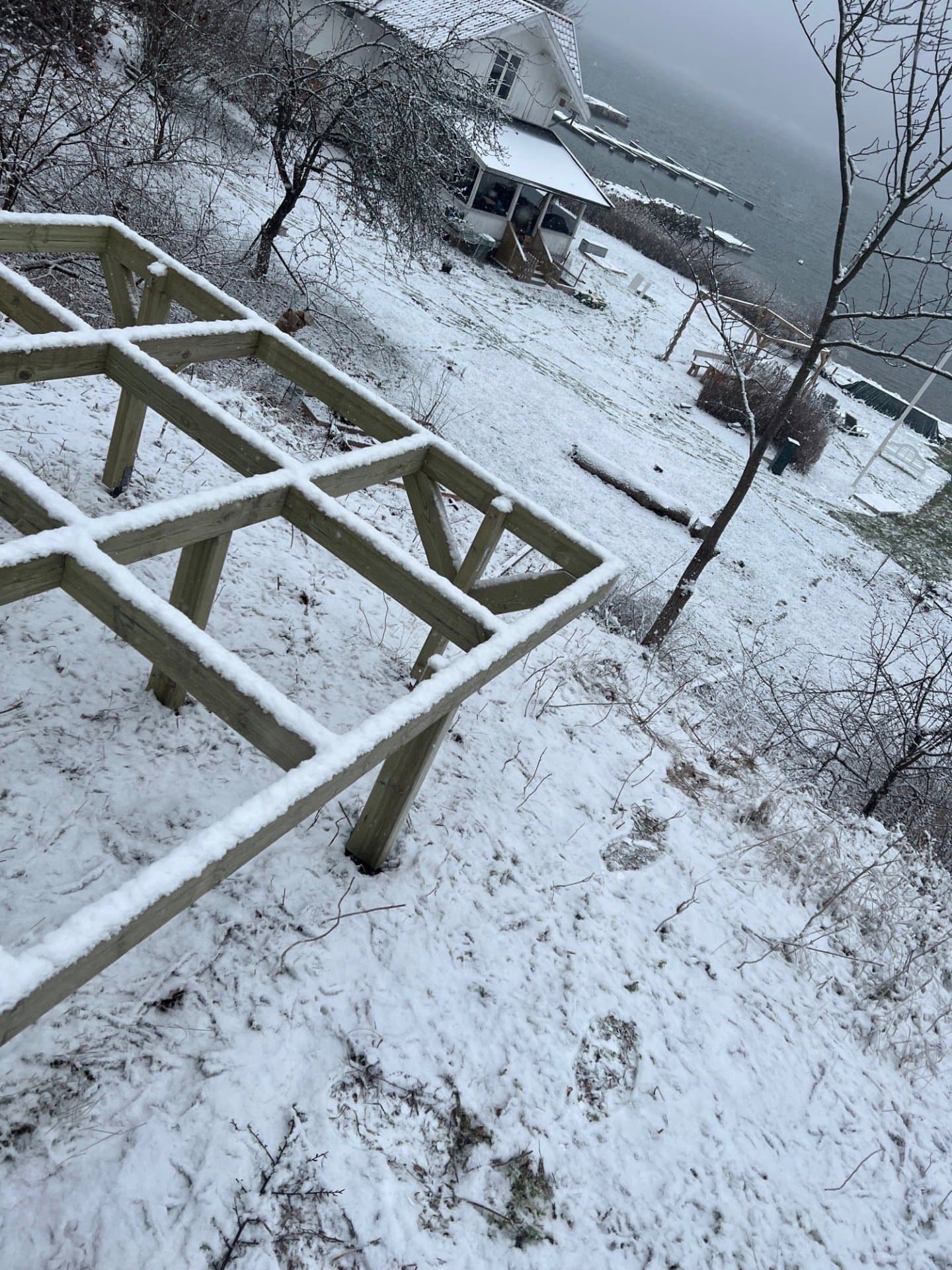 Fundament av tre på stolper i en skråning med snø